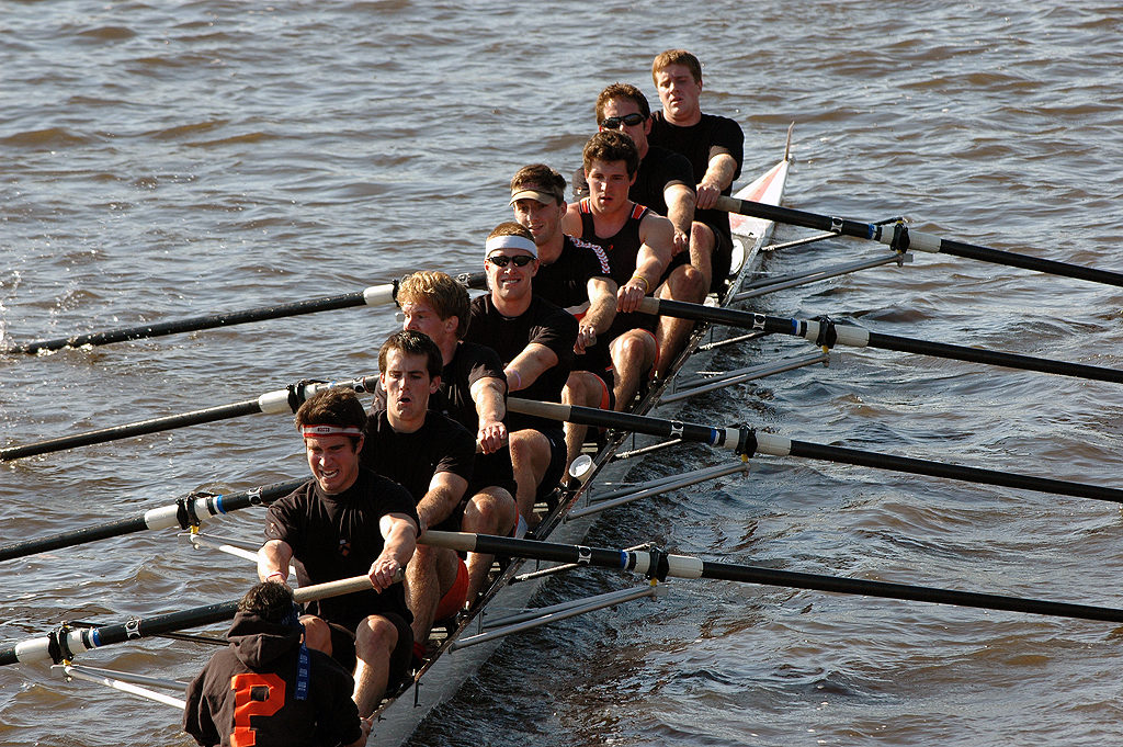 A group of people rowing a boat in a body of water