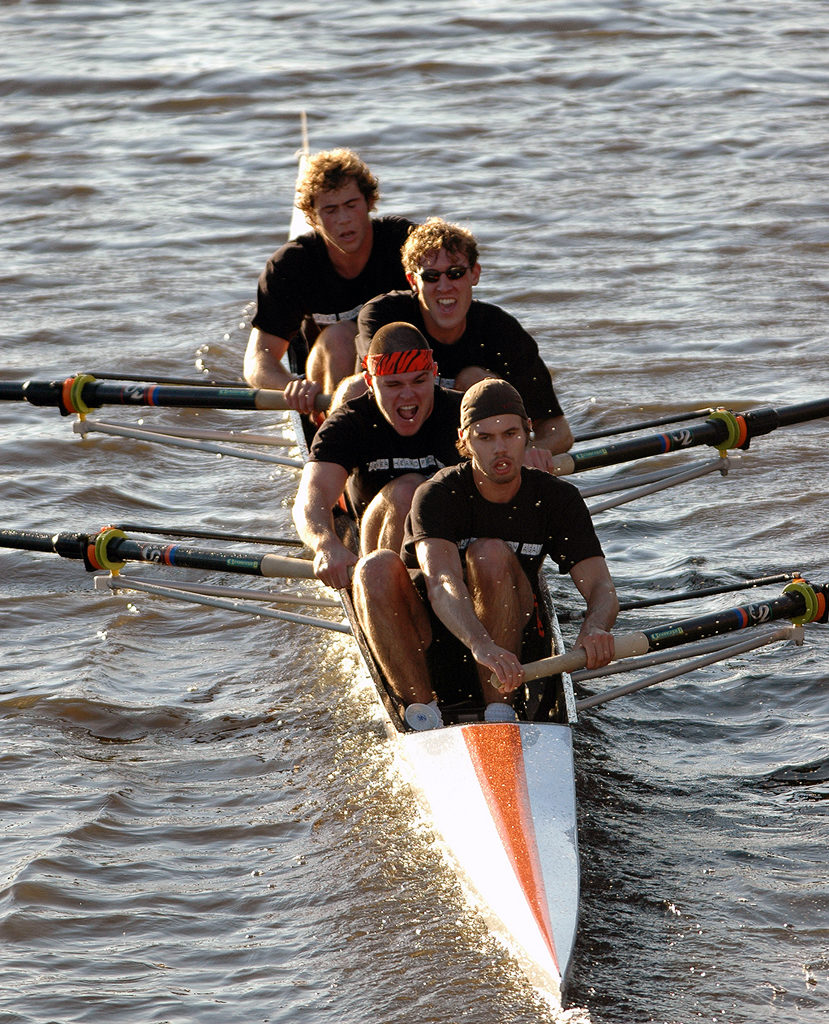 A group of people rowing a boat in the water