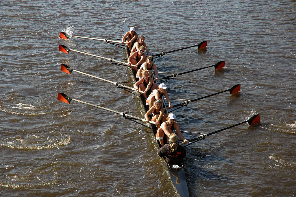 A group of people rowing a boat in the water