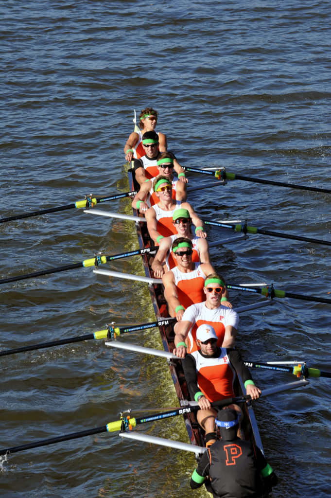 A group of people rowing a boat in the water