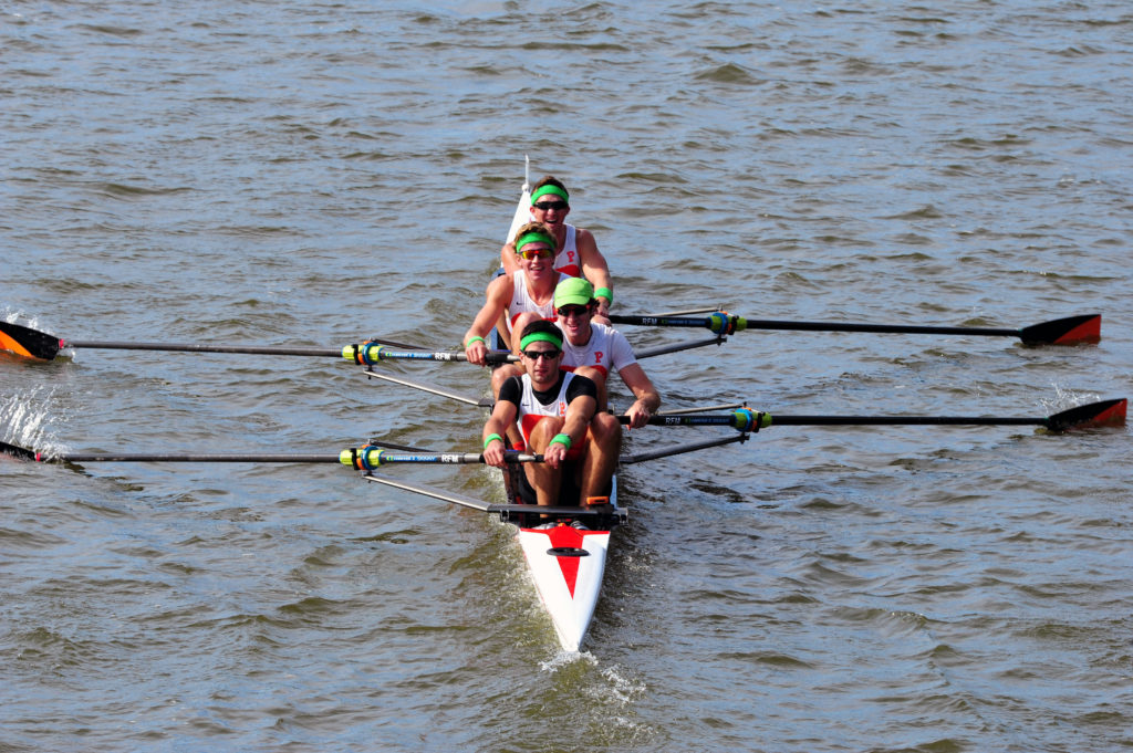 A group of people rowing a boat in the water