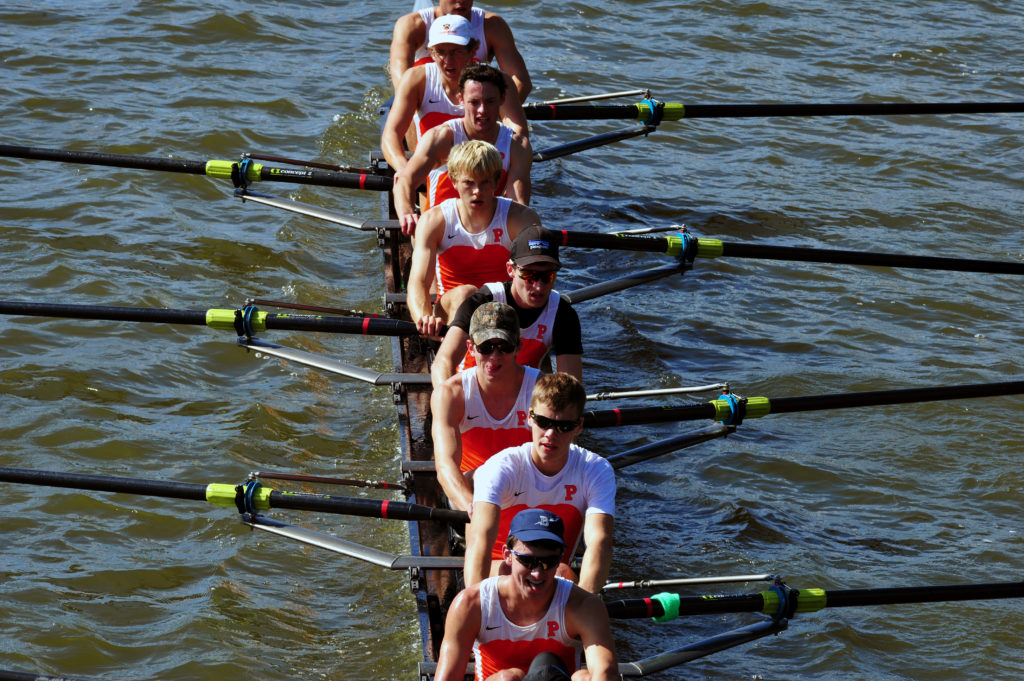 A group of people rowing a boat in a body of water