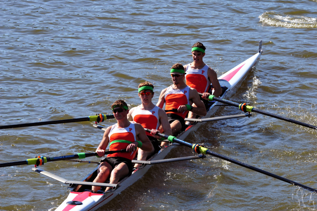 A group of people rowing a boat in a body of water