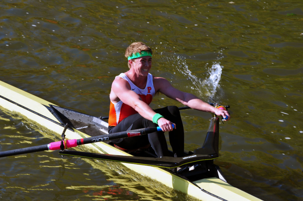 A man rowing a boat in a body of water