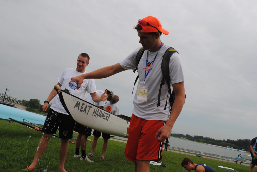 A man carrying a surf board in the grass