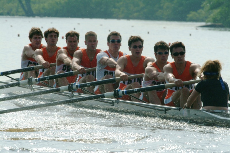 A group of people rowing a boat in the water