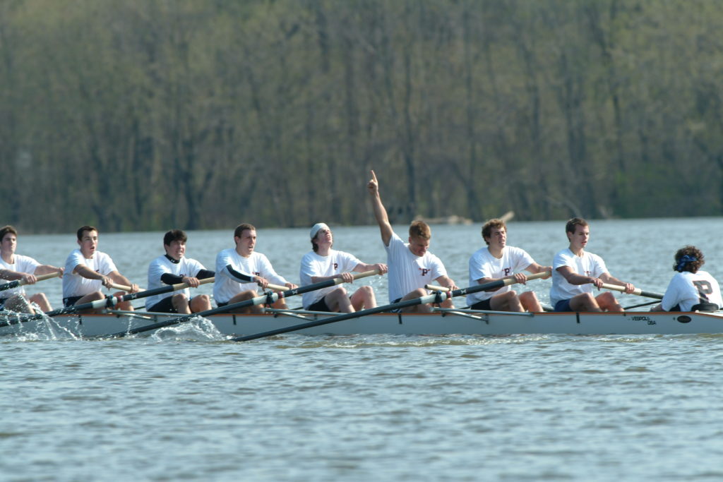 A group of people rowing a boat in the water