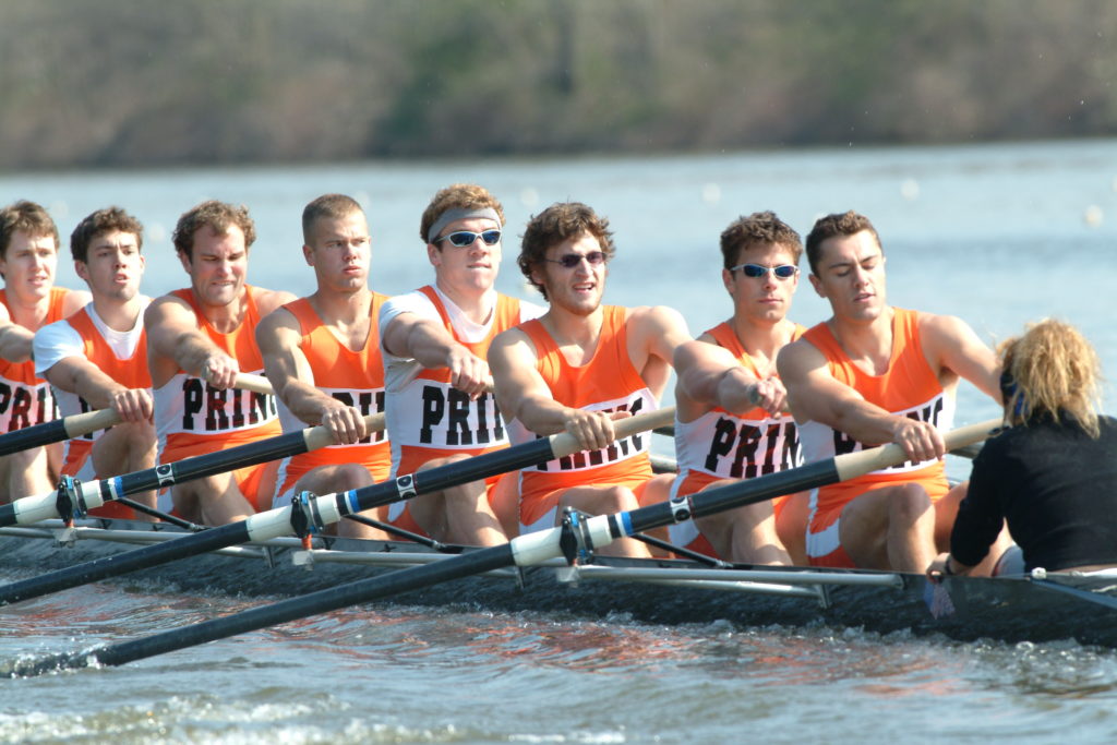 A group of people rowing a boat in the water