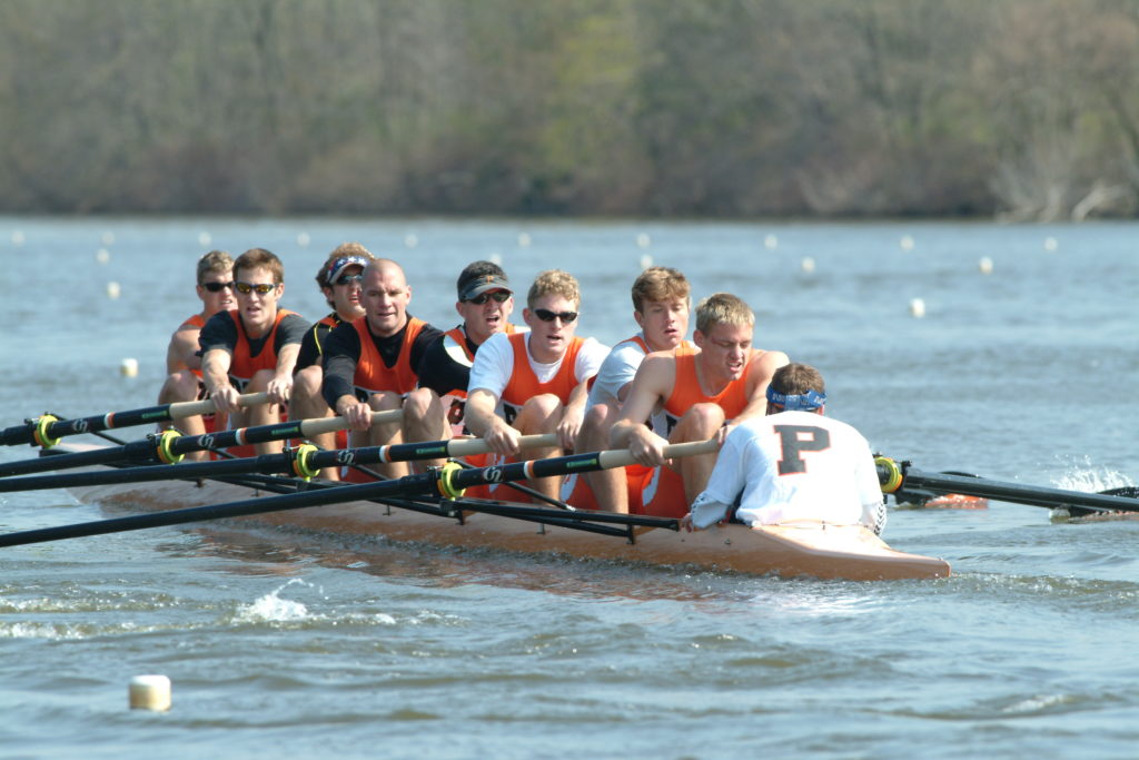 A group of people rowing a boat in the water