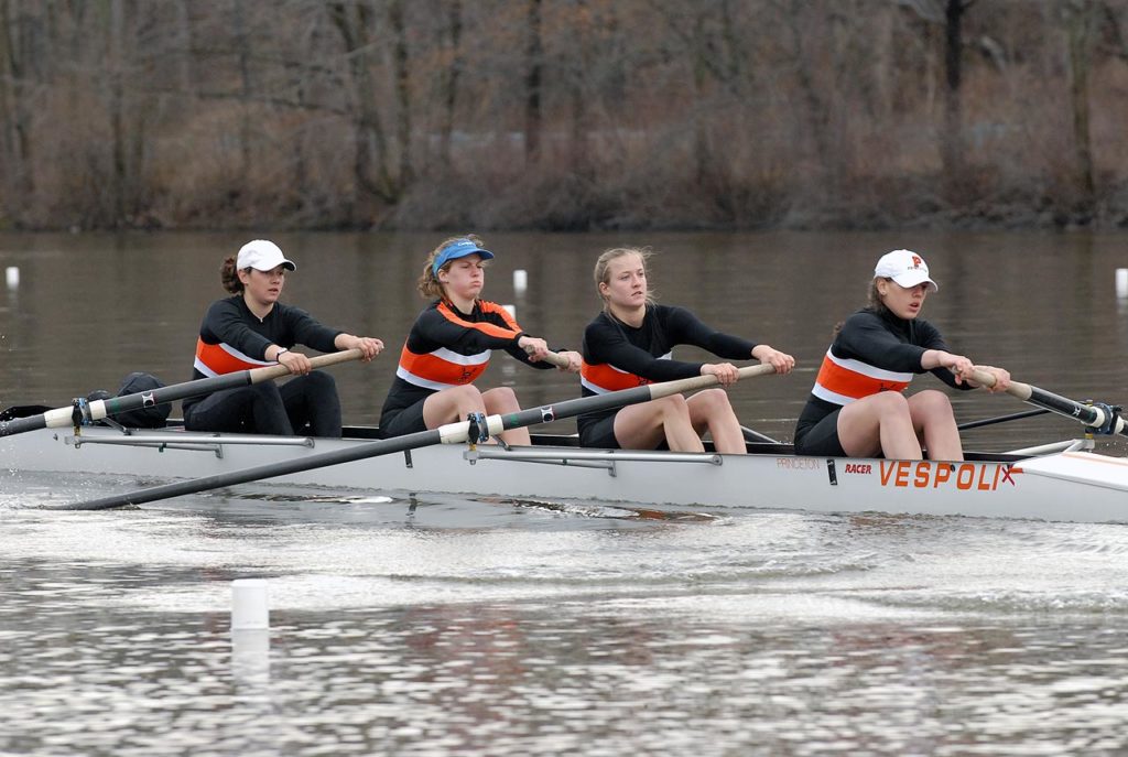 A group of people rowing a boat in the water