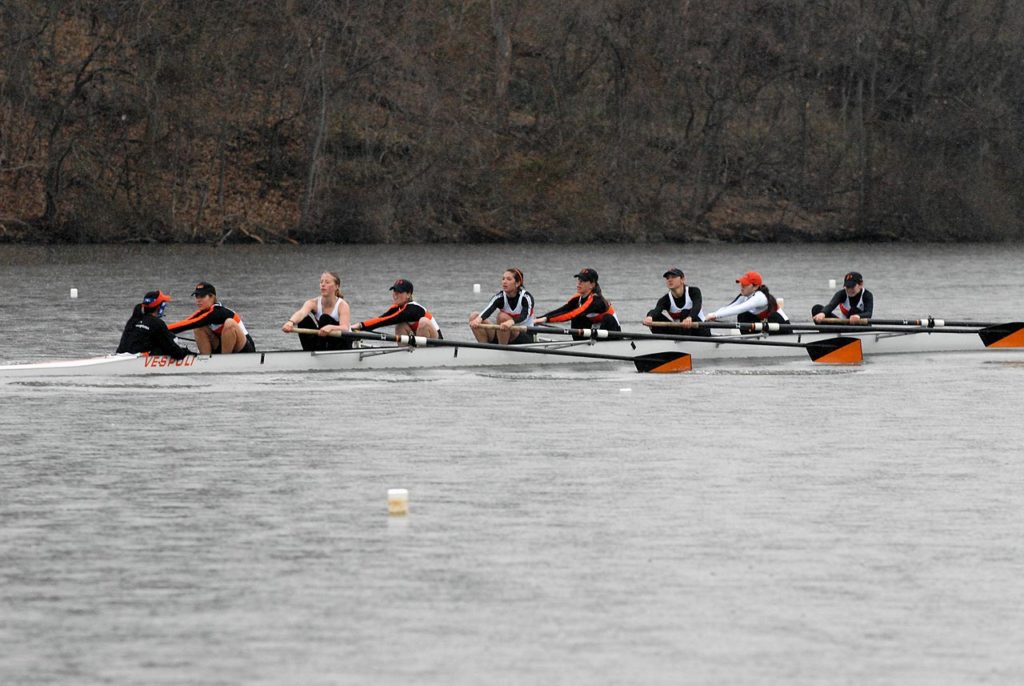 A group of people rowing a boat in the water