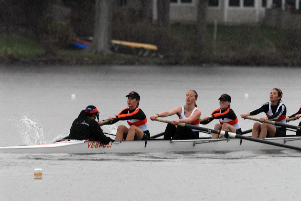 A group of people rowing a boat in the water