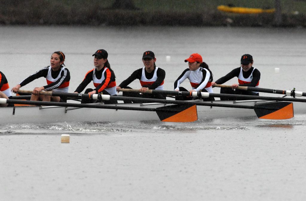 A group of people rowing a boat in the water