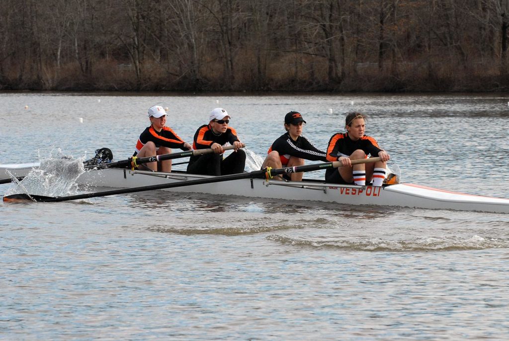 A group of people rowing a boat in the water