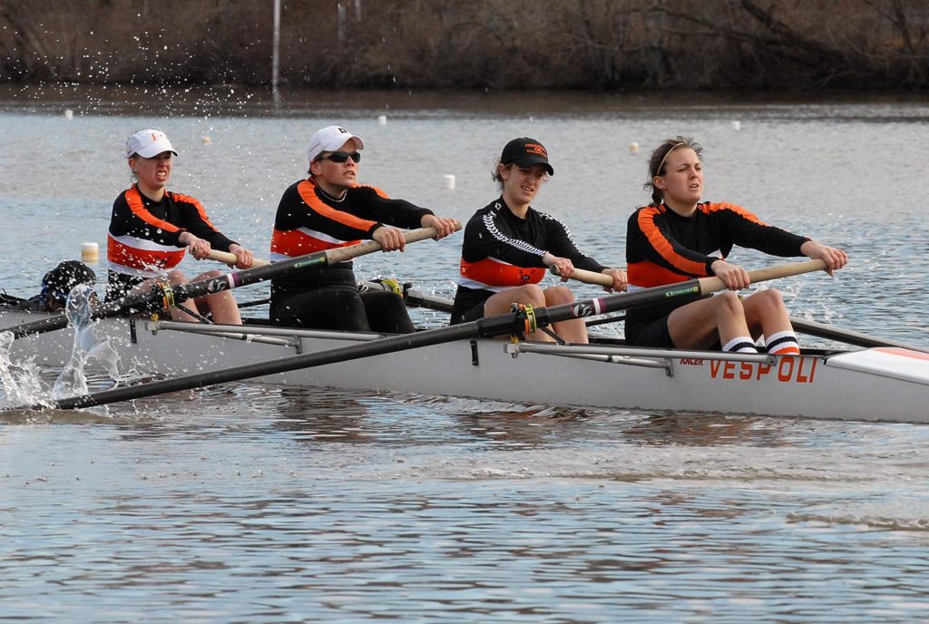 A group of people rowing a boat in the water