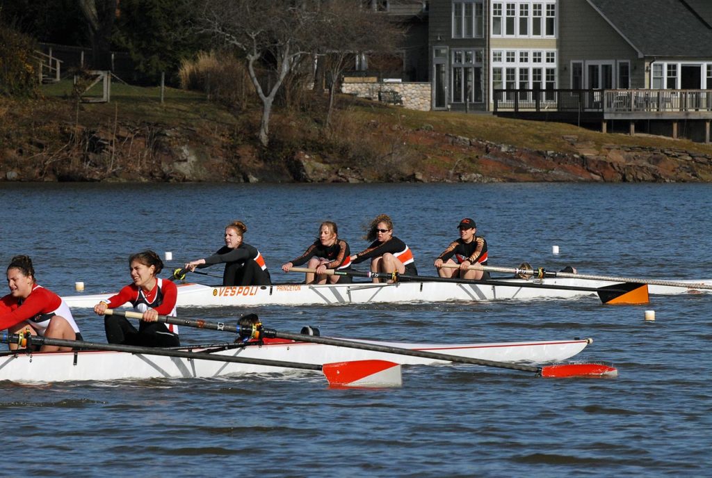 A group of people rowing a boat in the water