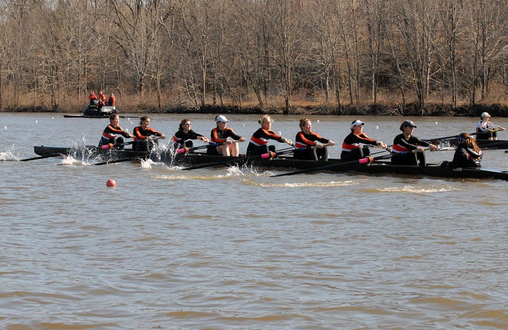 A group of people rowing a boat in the water