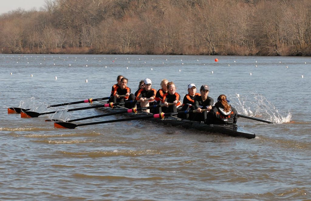 A group of people rowing a boat in the water