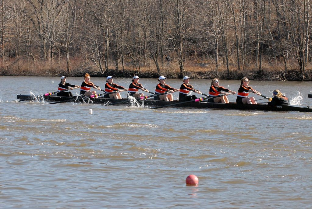 A group of people rowing a boat in the water