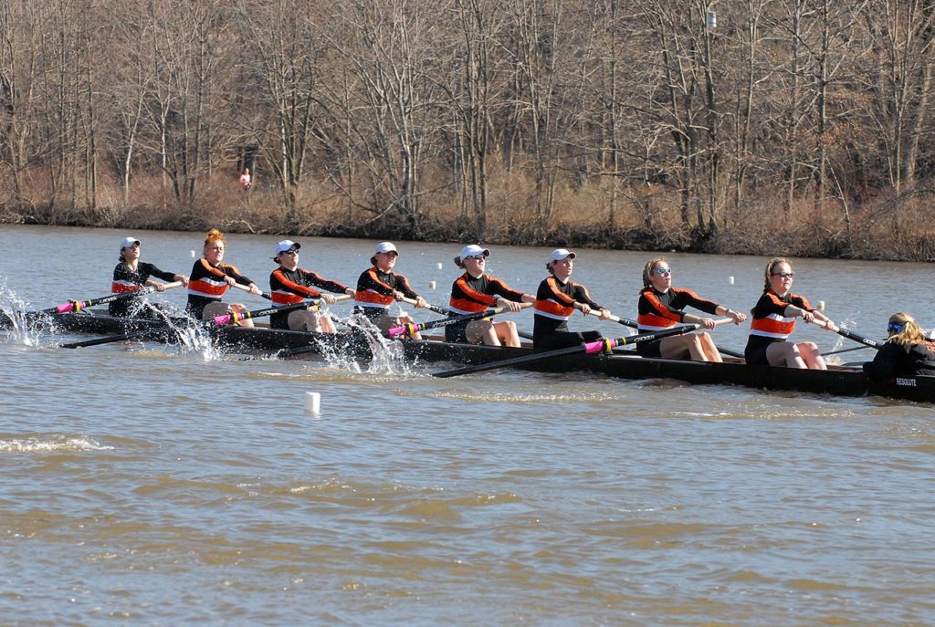 A group of people rowing a boat in the water