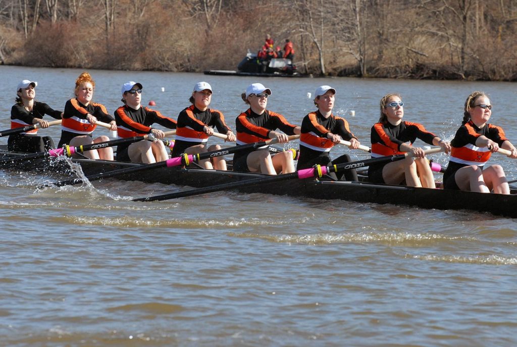 A group of people rowing a boat in the water