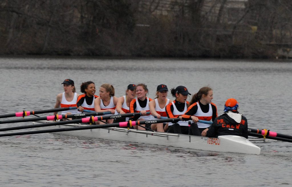 A group of people rowing a boat in the water