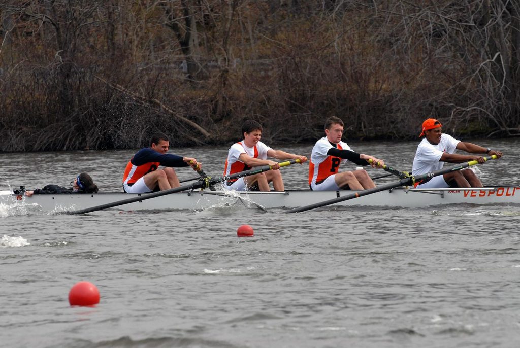 A group of people rowing a boat in the water