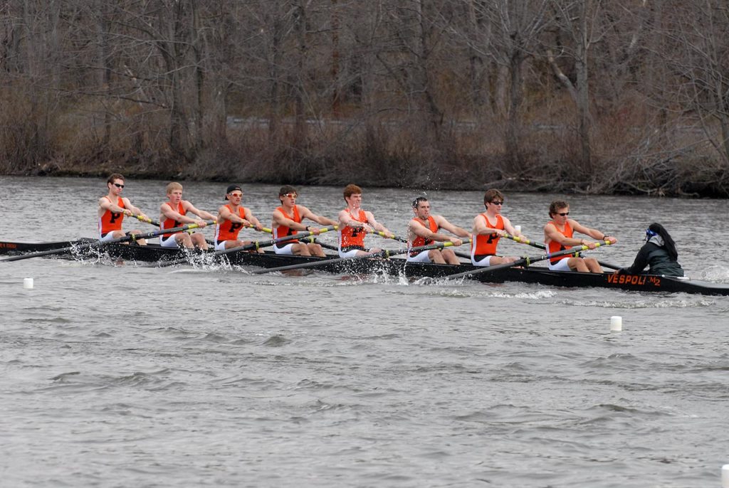 A group of people rowing a boat in the water