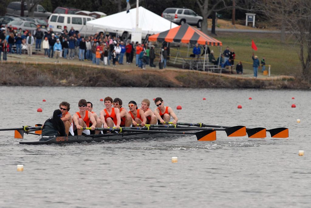 A group of people rowing a boat in the water