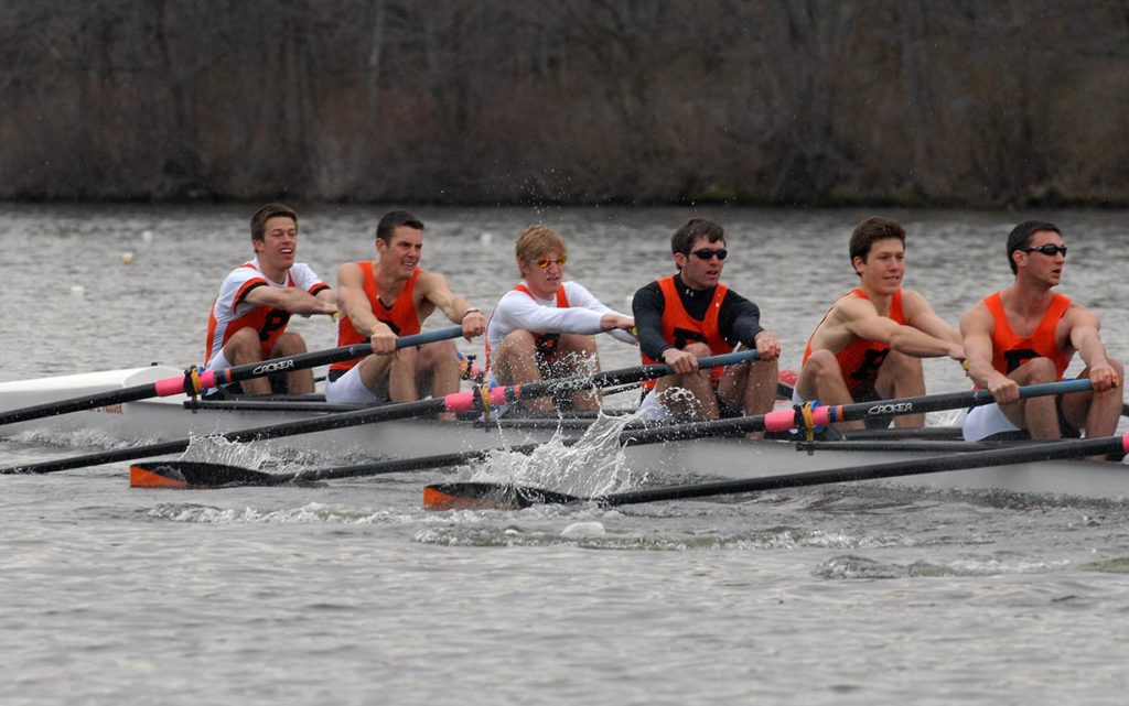 A group of people rowing a boat in the water