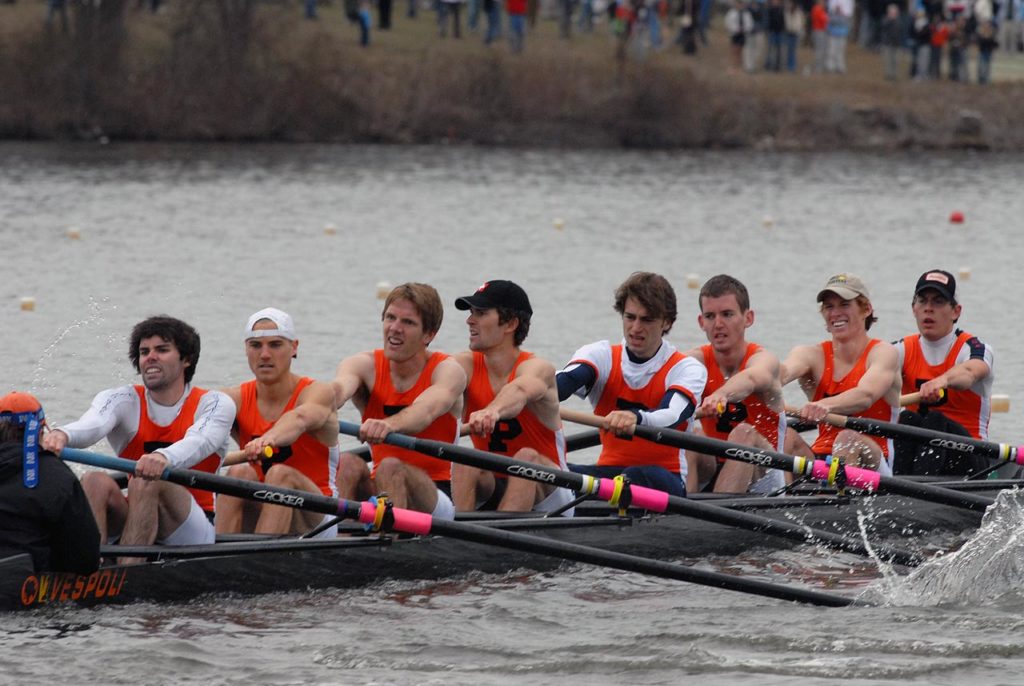 A group of people rowing a boat in the water