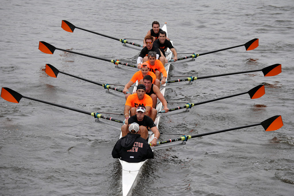 A group of people rowing a boat in the water