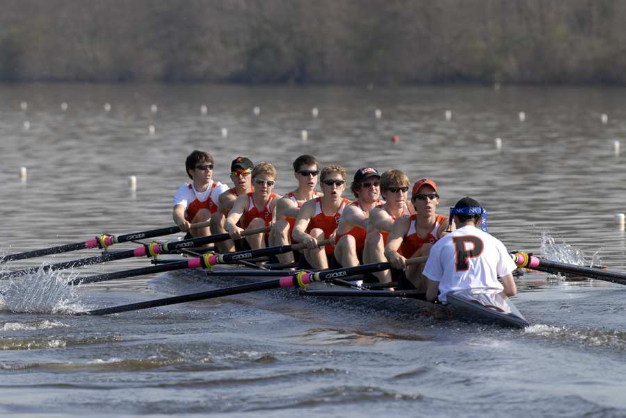 A group of people rowing a boat in a body of water