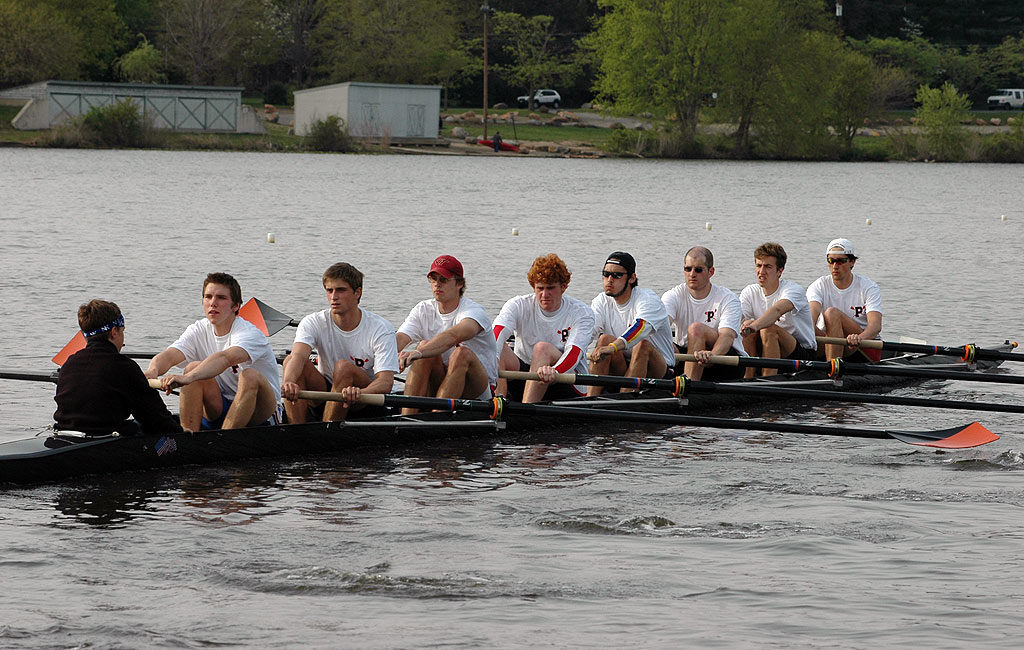 A group of people rowing a boat in the water