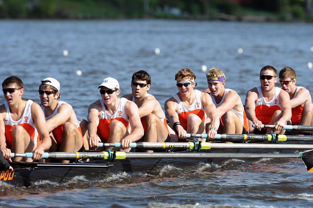 A group of people rowing a boat in the water