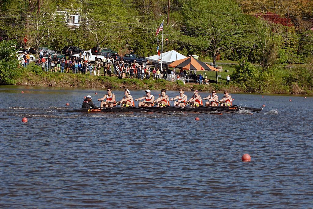 A group of people rowing a boat in a body of water