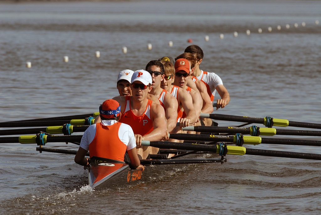 A group of people rowing a boat in the water