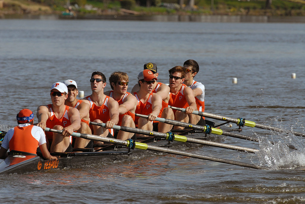 A group of people rowing a boat in a body of water