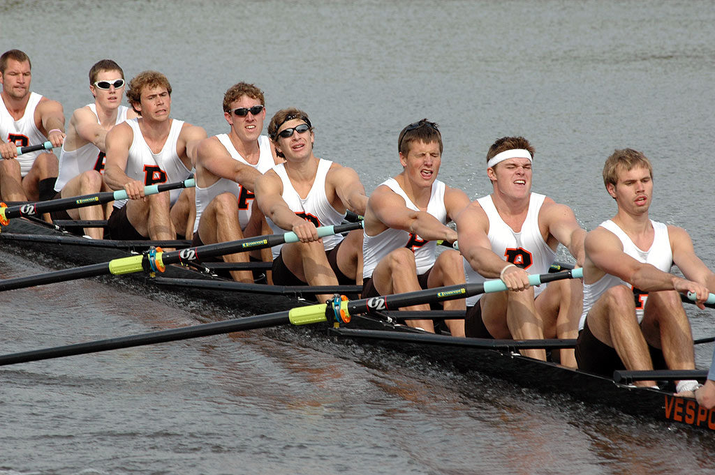 A group of people rowing a boat in the water