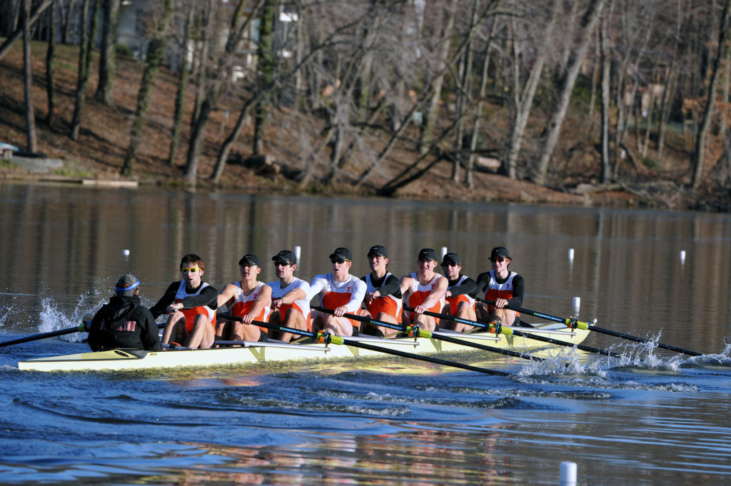 A group of people rowing a boat in the water