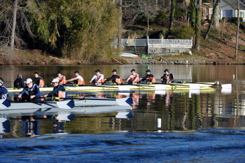 A group of people rowing a boat in the water