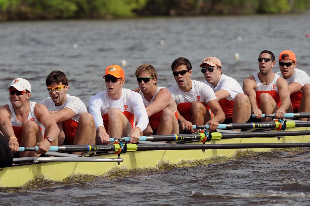 A group of people rowing a boat in the water