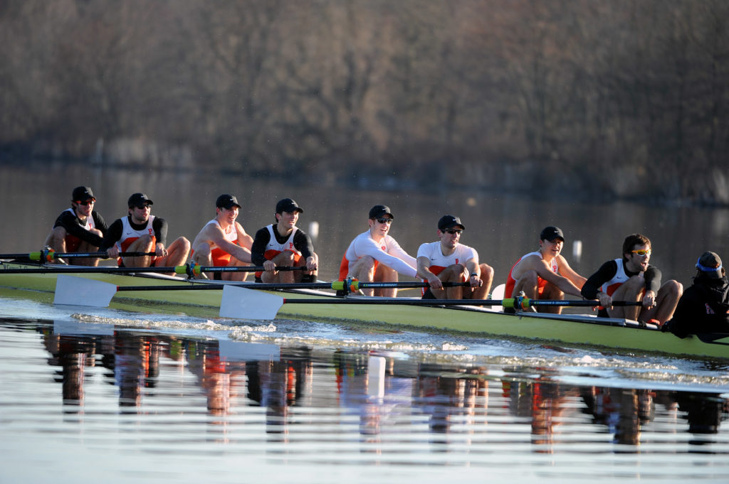 A group of people rowing a boat in the water