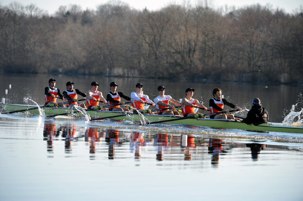 A group of people rowing a boat in the water