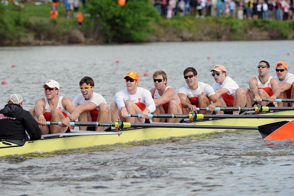 A group of people rowing a boat in the water