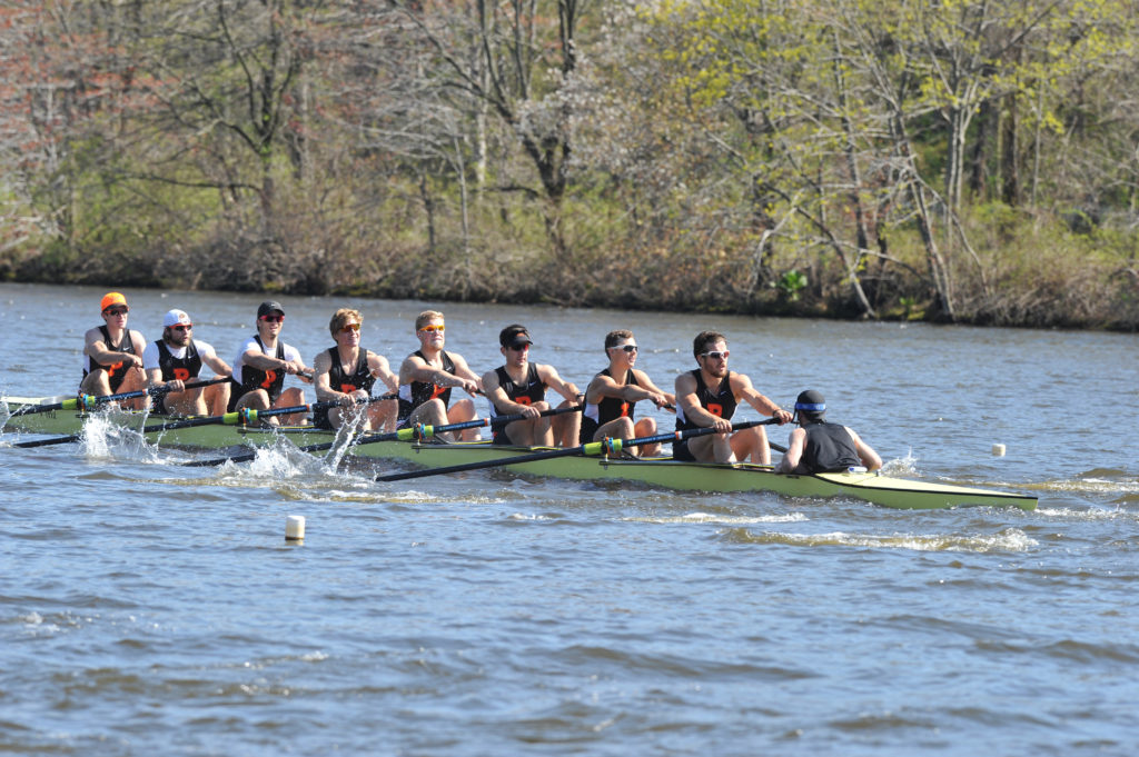 A group of people rowing a boat in a body of water