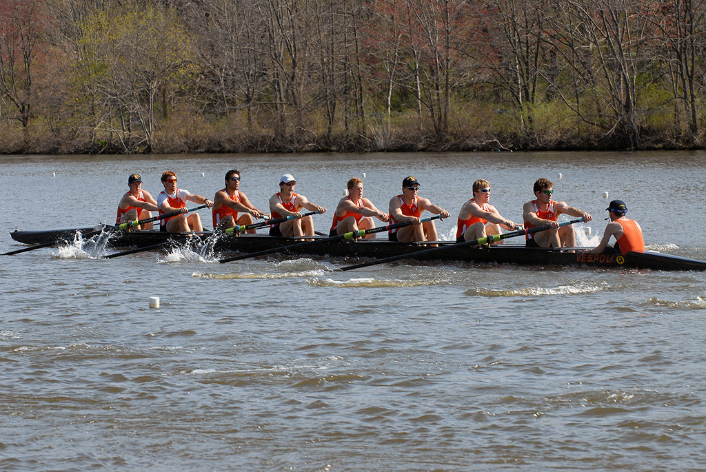 A group of people rowing a boat in a body of water