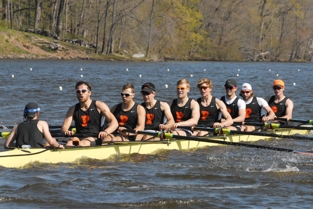 A group of people rowing a boat in the water