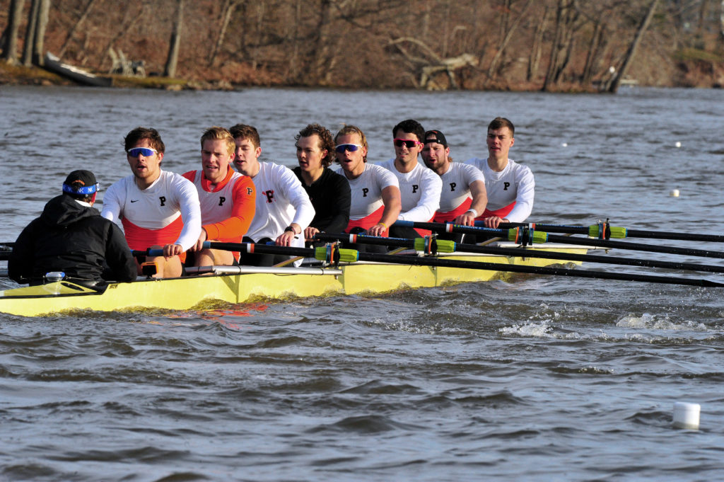 A group of people rowing a boat in the water