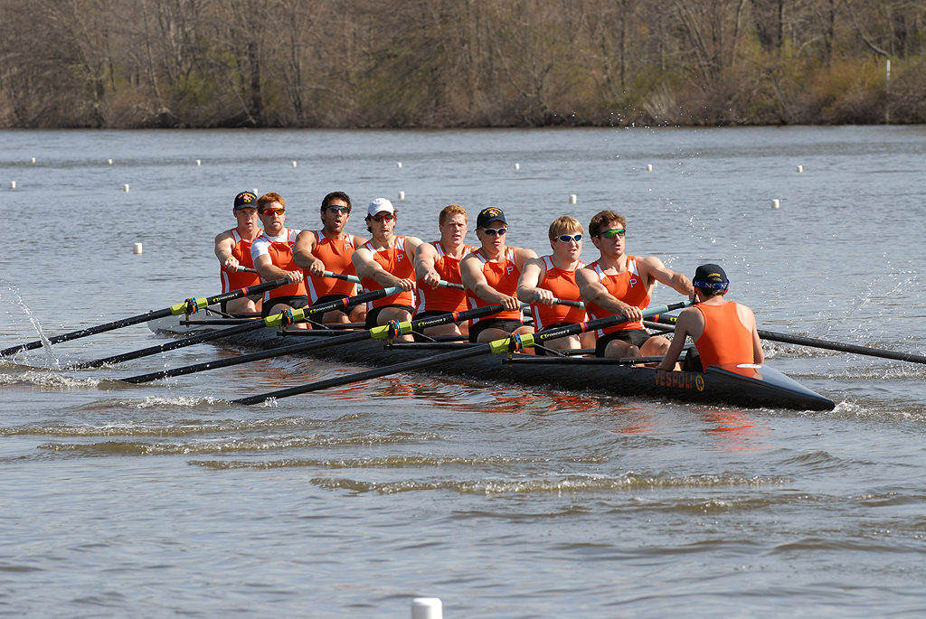 A group of people rowing a boat in the water